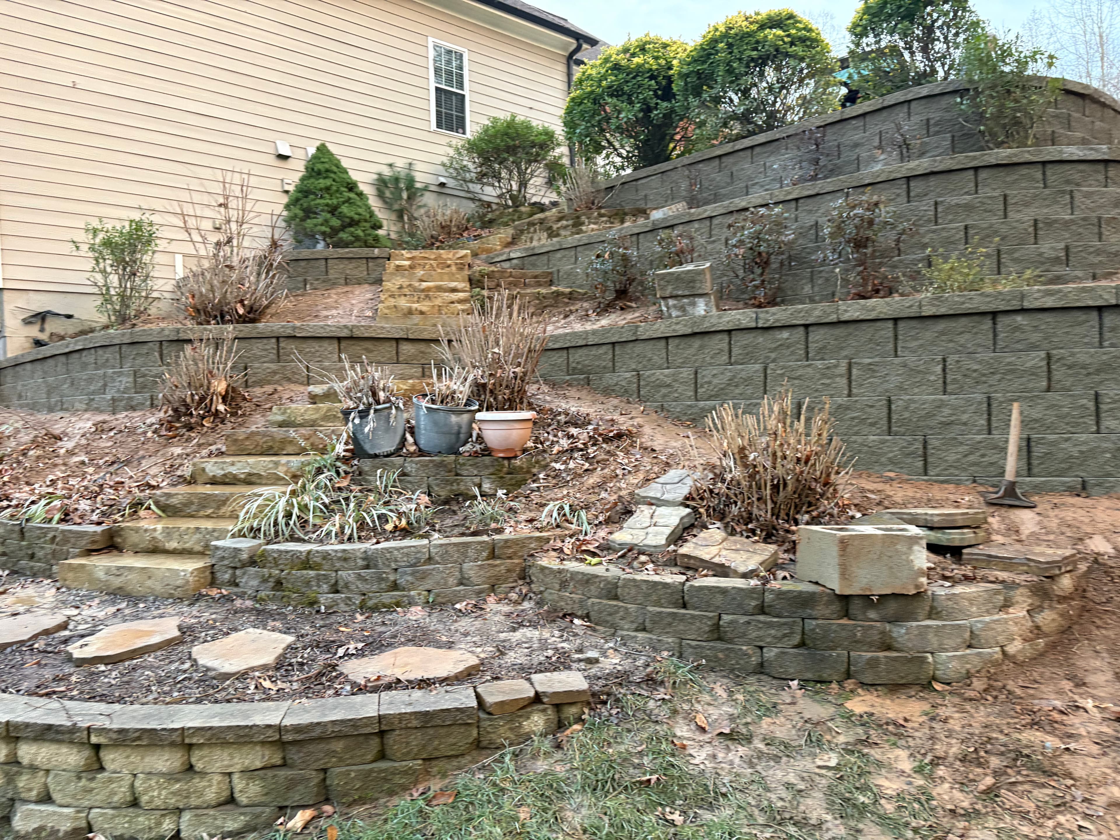 Multi-tiered retaining wall system with stone steps